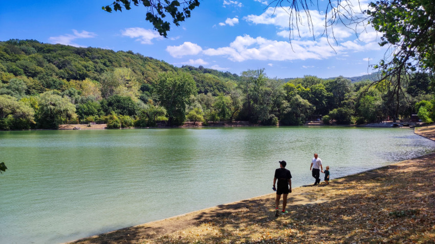 Люди на берегу озера «Трек» на фоне лесистых склонов Нальчика