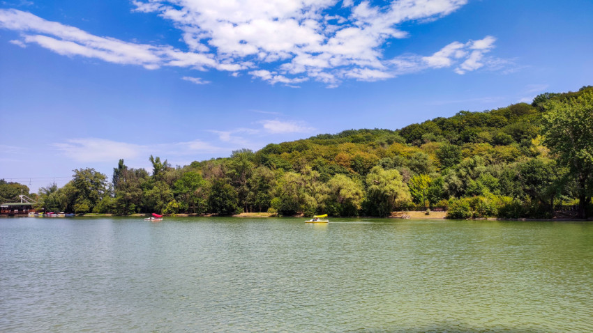 Озеро «Трек» с катамаранами на фоне зелёных склонов Атажукинского сада