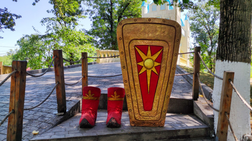 Декоративный рыцарский щит и большие красные сапоги в фотозоне Городского парка Нальчика