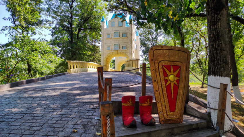 Рыцарская фотозона у парковой дорожки на фоне башни-арки в Городском парке Нальчика