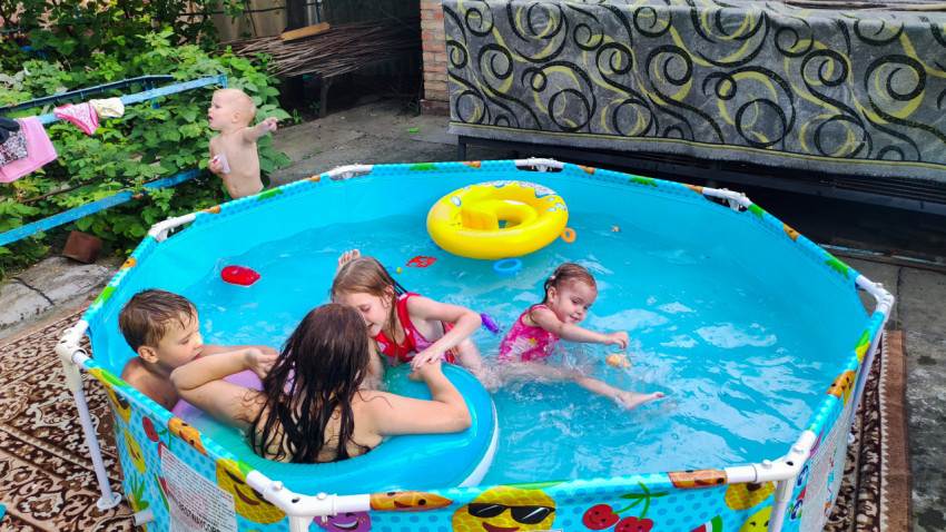 Дети купаются в каркасном бассейне во дворе частного дома
