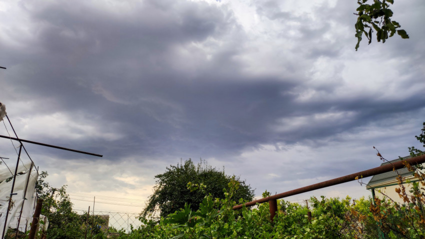 Грозовые тучи над дачным участком и теплицей