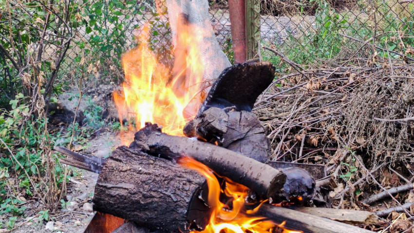 Горящие поленья у забора крупным планом