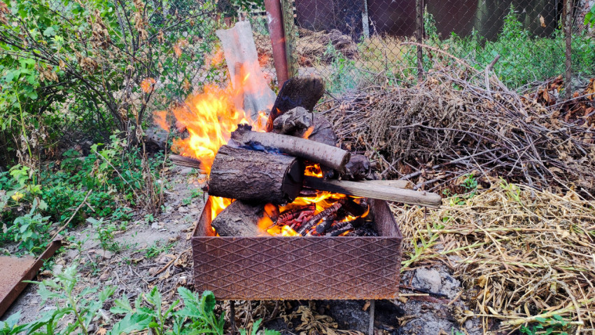 Огонь в металлической жаровне на дачном участке