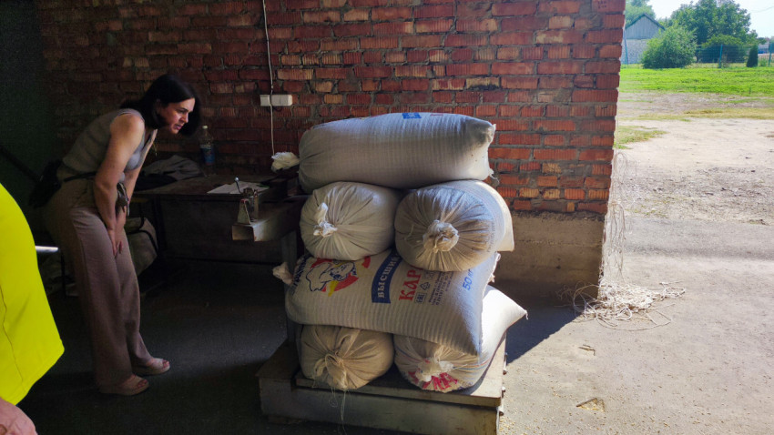 Взвешивание мешков с кормом на платформенных весах в сельском складе