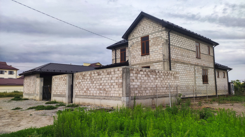 Недостроенный дом из блоков с забором и воротами