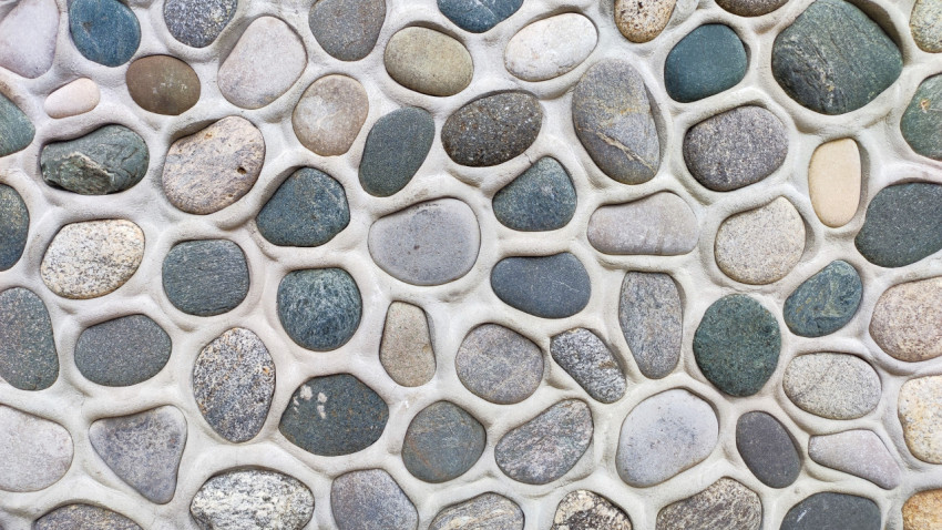 Текстура стены из округлой гальки, уложенной в светлый раствор