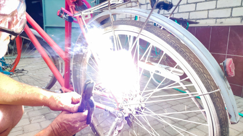 Вспышка дуги при сварке багажника велосипеда во дворе