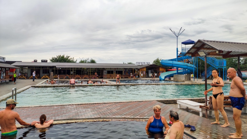 Панорама бассейнов с водной горкой и зоной отдыха посетителей