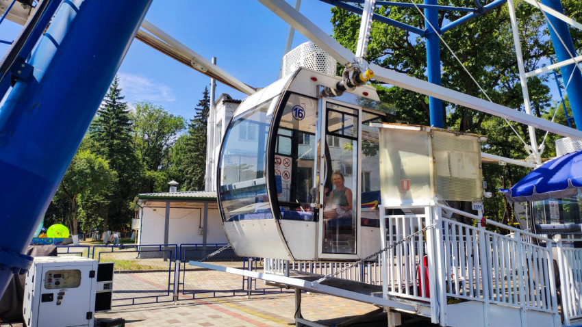 Кабина колеса обозрения у посадочной платформы в парке