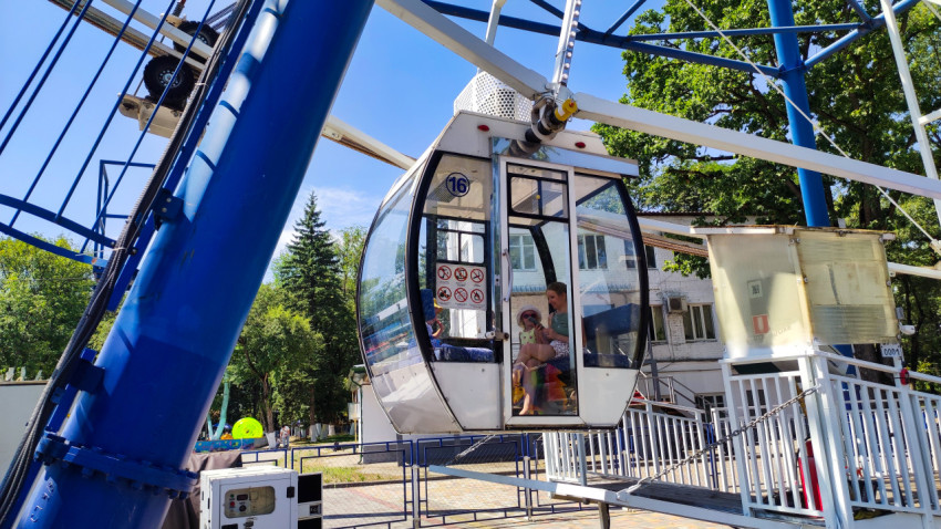 Посетители в кабине колеса обозрения перед началом движения