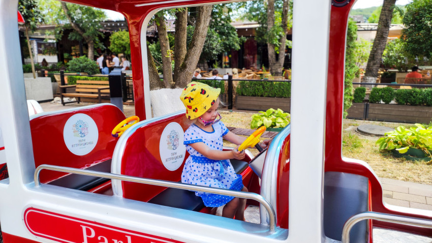 Девочка за рулём детского аттракциона в Городском парке Нальчика