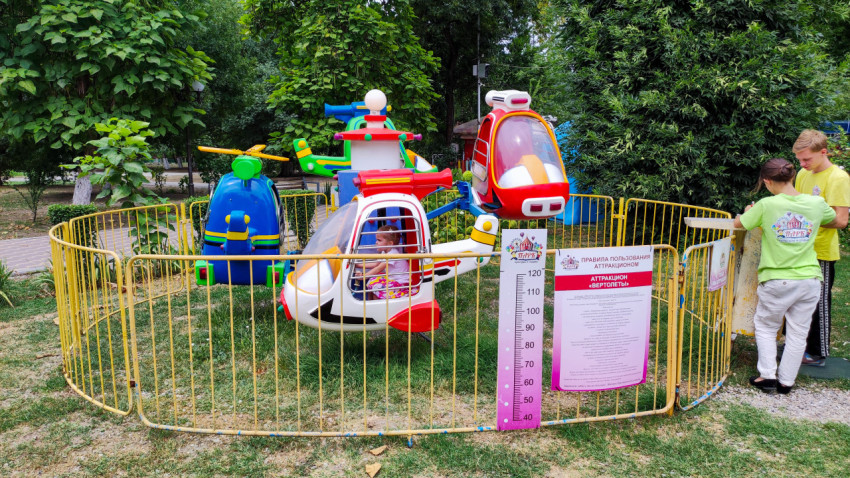 Детский аттракцион с вертолётами в ограждённой зоне Комсомольского парка Прохладного