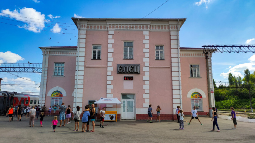 Вид на фасад вокзала «Елец» с пассажирами и платформой у поезда