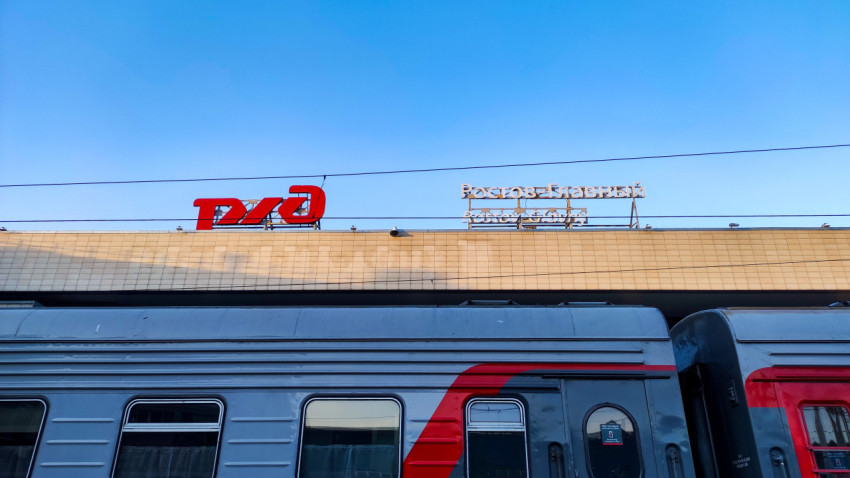 Вывеска «Ростов-Главный» и логотип РЖД над пассажирским вагоном на перроне