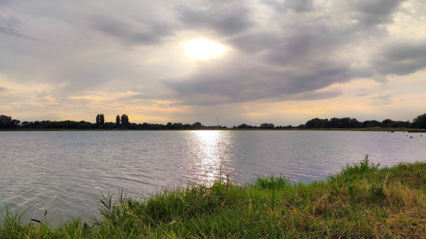 Закатный свет над озером и отражение на воде