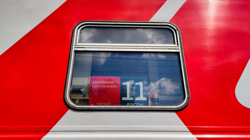 Окно пассажирского вагона с табличкой маршрута «Владикавказ — Санкт-Петербург»