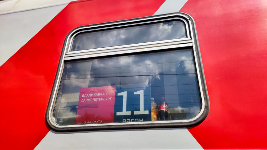 Окно пассажирского вагона с табличкой маршрута Владикавказ – Санкт-Петербург и номером 11