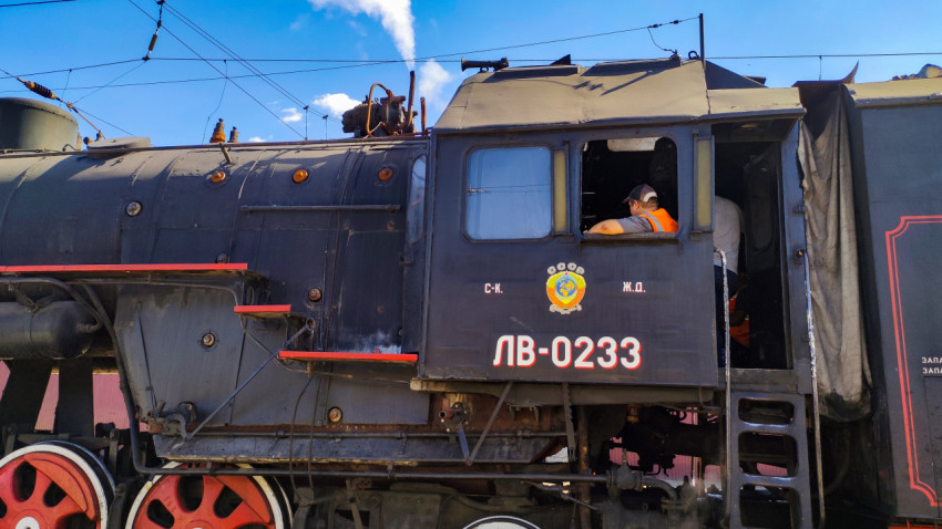 Боковой план паровоза ЛВ-0233 с машинистом в кабине и струёй пара