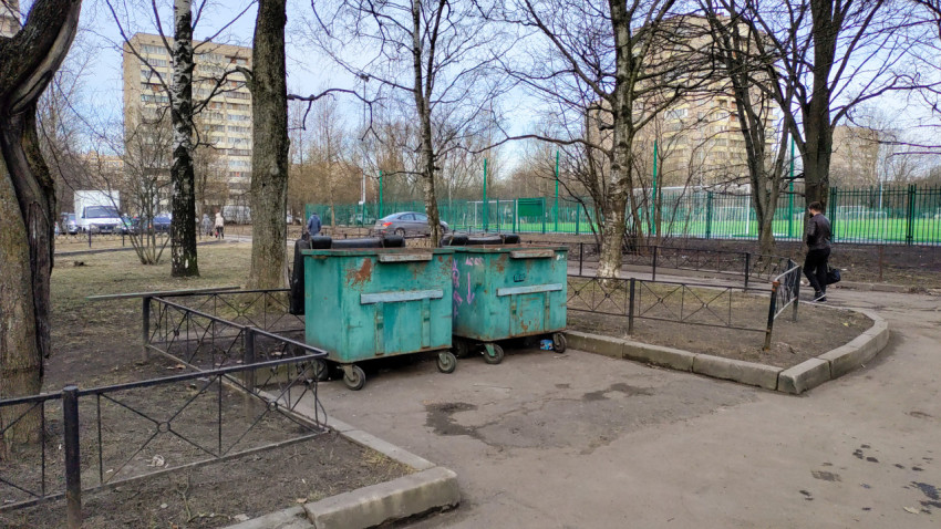 Передвижные мусорные баки во дворе жилого дома