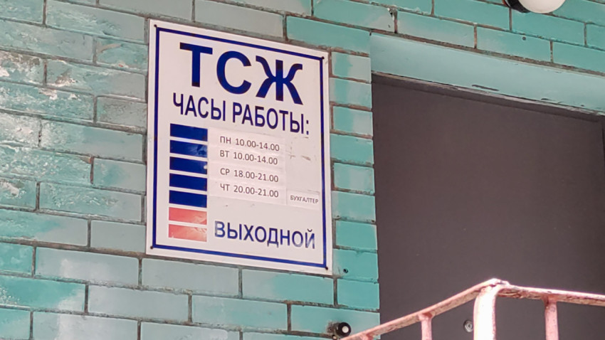 Табличка с графиком работы ТСЖ на бирюзовой кирпичной стене