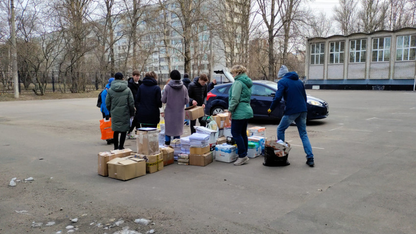 Школьники и волонтёры сортируют макулатуру на парковке