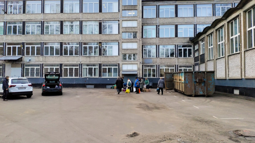 Люди участвуют в уличной акции по сбору макулатуры