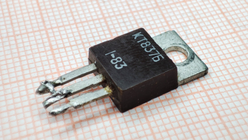 Биполярный транзистор КТ837Б на фоне миллиметровой бумаги