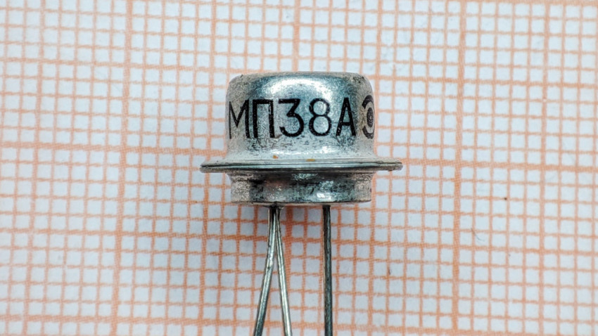 Транзистор МП38А на фоне миллиметровки