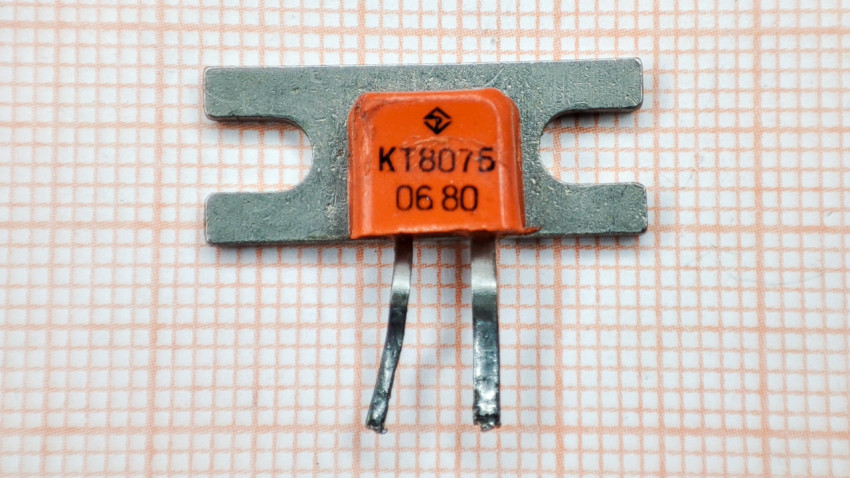 Транзистор КТ807Б на фоне миллиметровой бумаги
