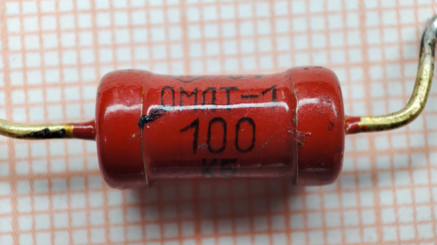 Резистор ОМЛТ-1 номиналом 100 Ом на фоне миллиметровки