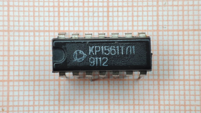 Микросхема КР1561ТЛ1 на фоне миллиметровой бумаги