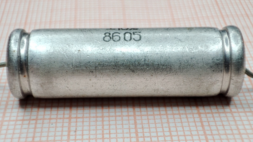 Металлобумажный конденсатор МБМ 8605 крупным планом на фоне бумаги в клетку