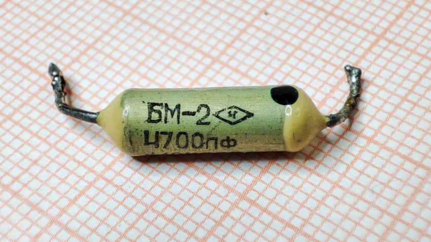 Бумажный конденсатор БМ-2 4700 пФ на фоне бумаги в клетку