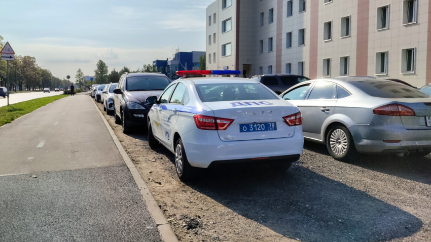 Автомобиль ДПС, припаркованный вдоль дороги у здания полиции