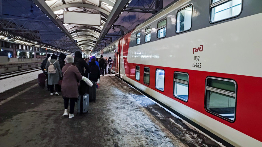 Люди возле красно-белого поезда на платформе Московского вокзала в Санкт-Петербурге