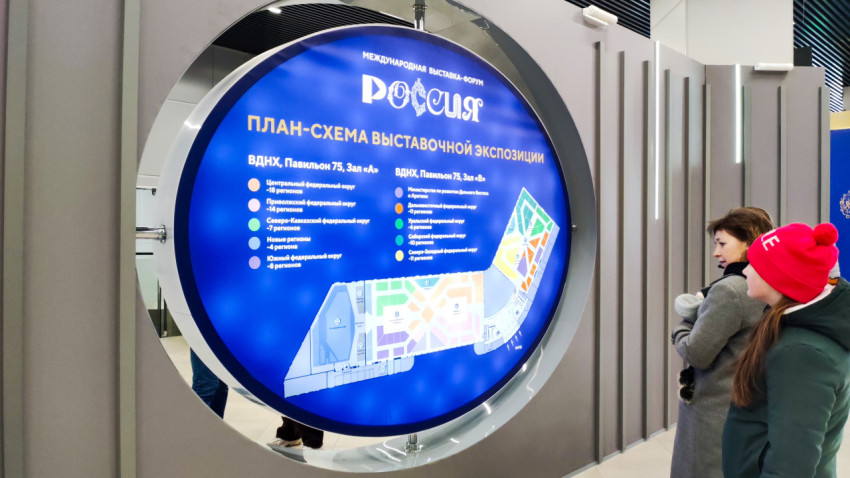 Люди стоят перед план-схемой выставочной экспозиции