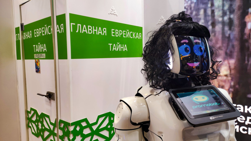 Женский робот стоит перед стеной