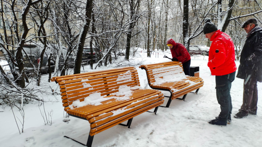 Уборка снега с лавочек в зимнем парке