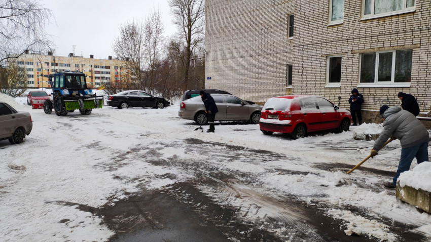 Уборка снега во дворе жилого дома в зимний день