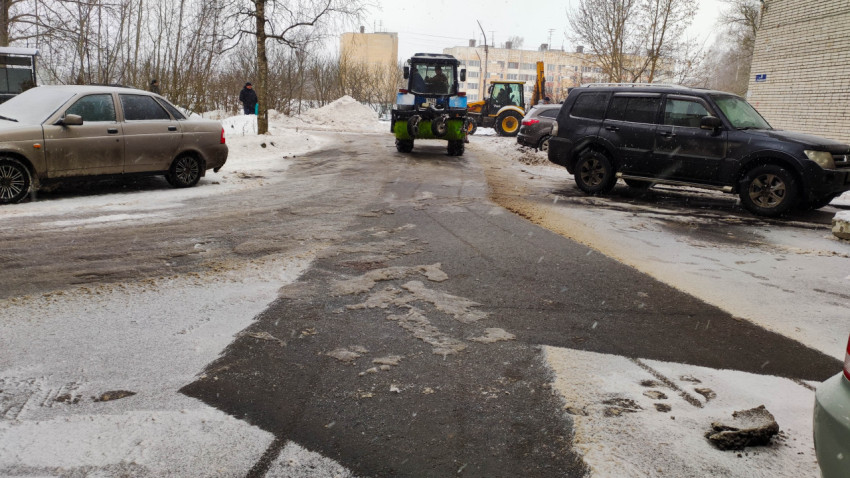 Трактор очищает снег во дворе жилого комплекса зимой