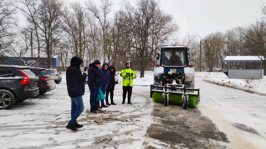 Трактор очищает дорогу от снега в зимний день в городе