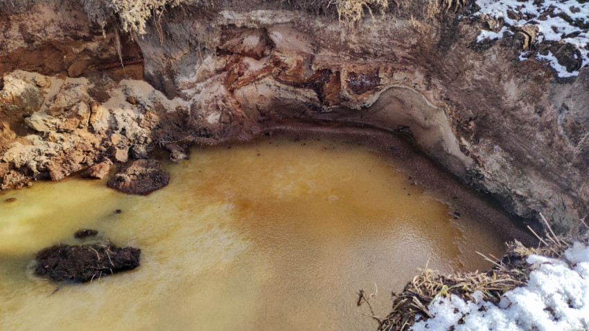 Замерзшая вода в выкопанной яме