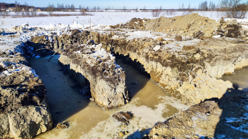 Яма для укладки труб на стройплощадке в сельской местности