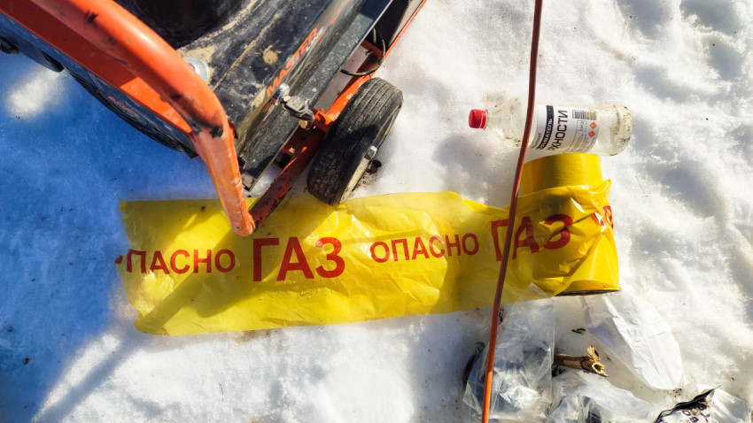 Желтая лента с надписью «Опасно газ» на снегу