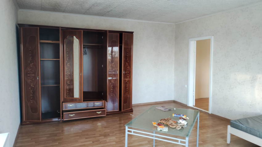 Шкаф в углу комнаты с низким столом и кроватью