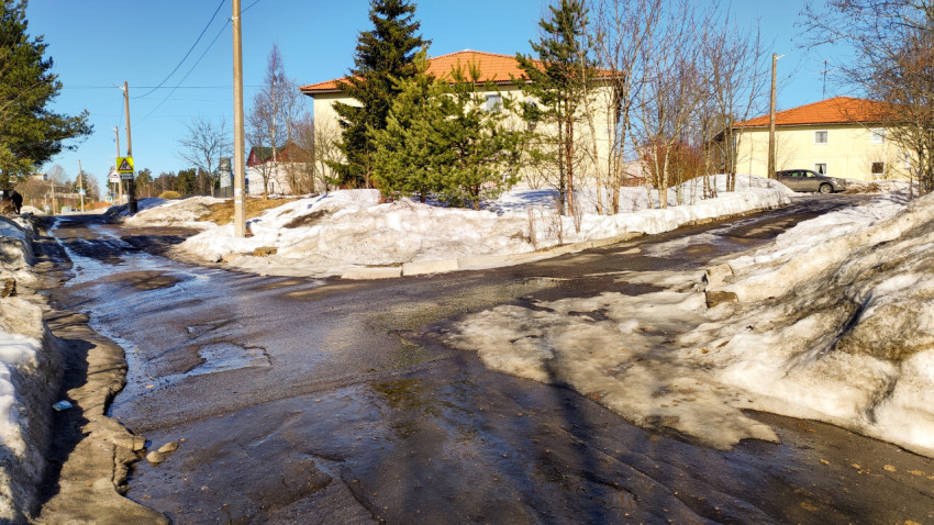 Весенний пейзаж с тающим снегом и солнечным небом в пригороде