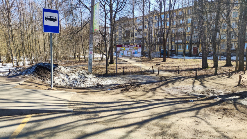 Двор многоквартирного дома с автобусной остановкой и деревьями