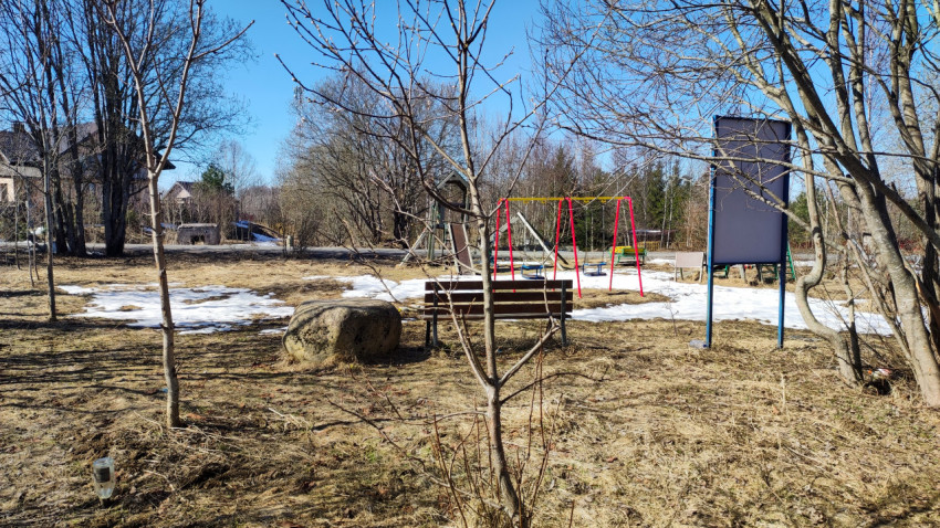 Детская площадка с качелями и горкой в весеннем парке