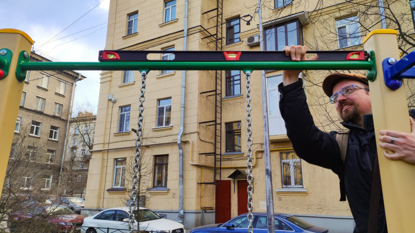 Измерение уровня перекладины на детской площадке во дворе